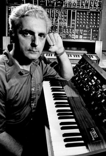 Robert Moog working intently in his basement studio, surrounded by the revolutionary modular synthesizer equipment he invented